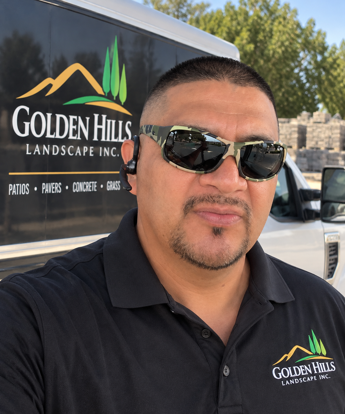 Alonso, owner of Golden Hills Landscape, standing in front of a company truck with the Golden Hills logo