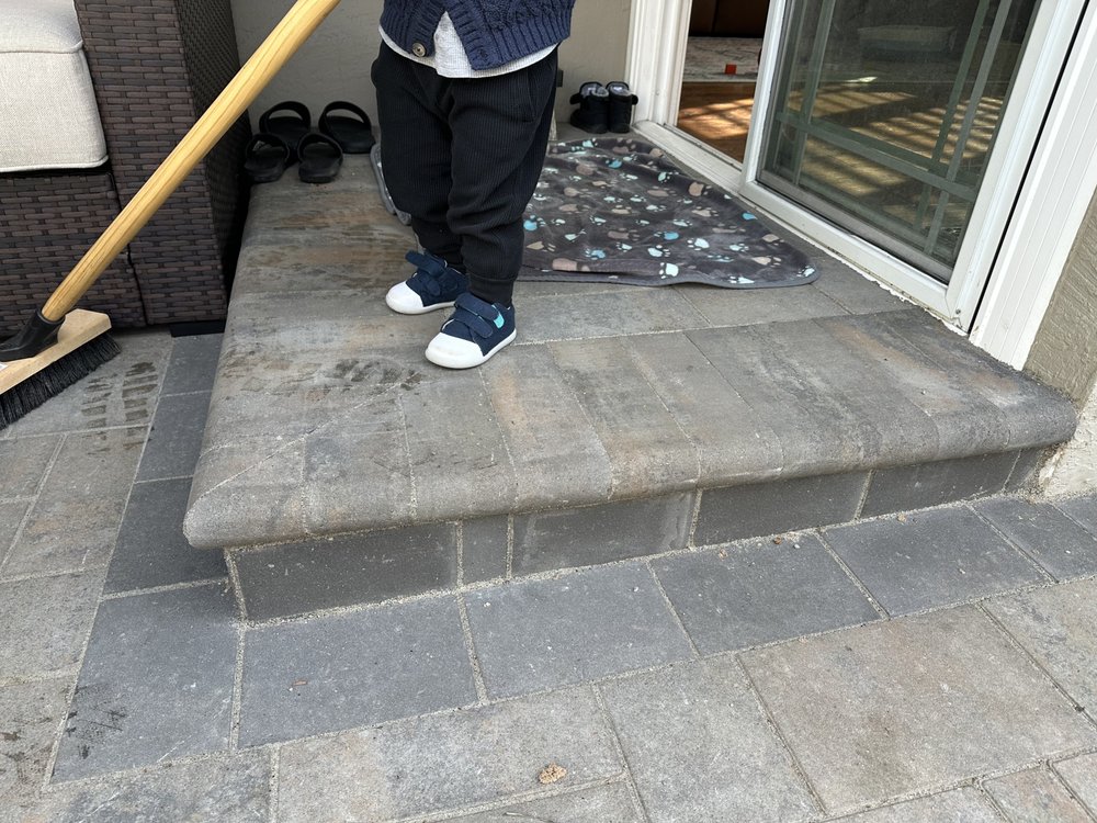 Close view of the finished bullnose paver step and dark paver band at the sliding door