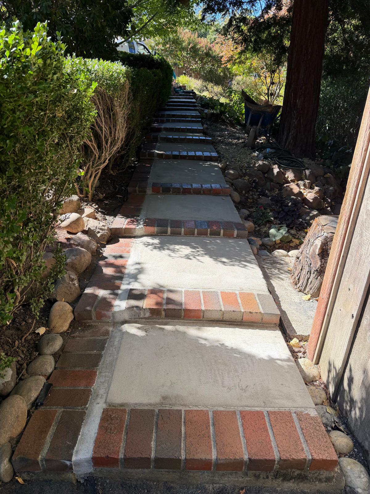After: restored stairway at Georgeta’s Lafayette property, with smooth new concrete treads between red brick step edges