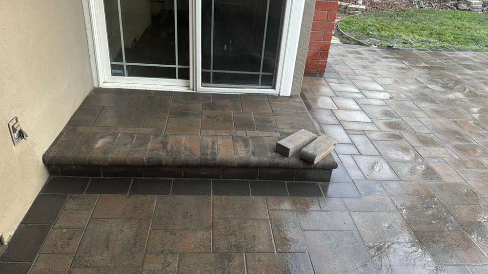 New bullnose paver step in front of a sliding glass door, on the freshly laid Fremont patio